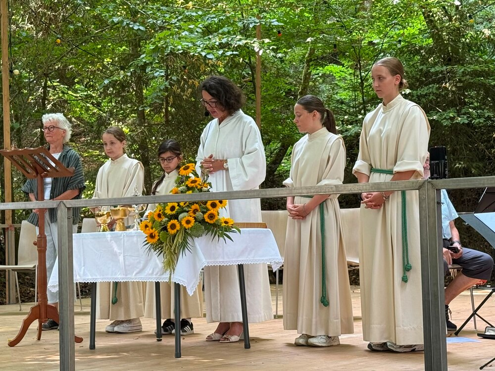 Waldgottesdienst unter schattigen Bäumen